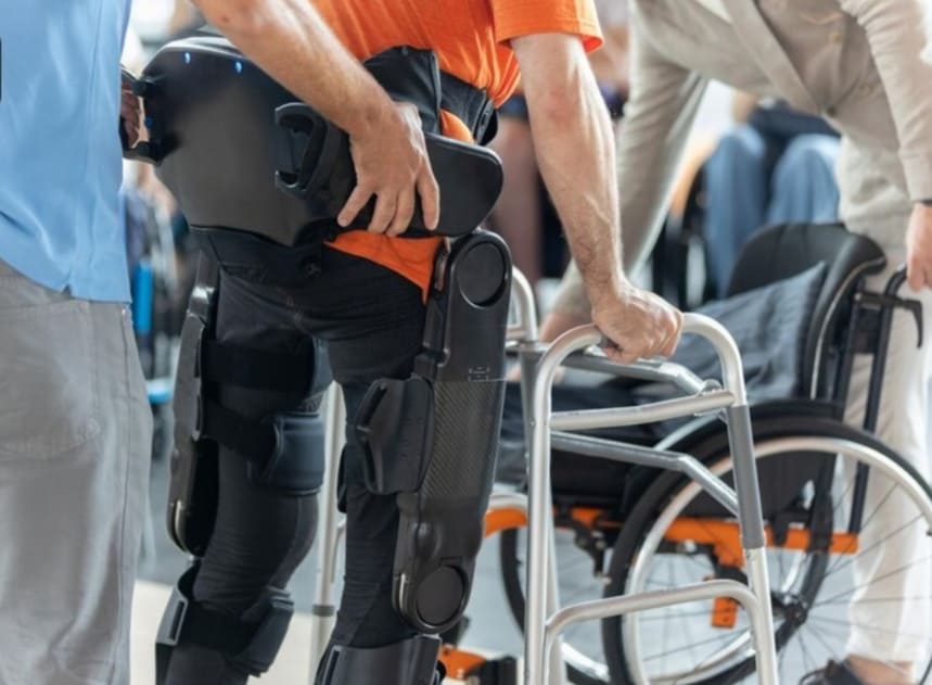 persona utilizando exoesqueleto para rehabilitacion con apoyo de andador en centro especializado